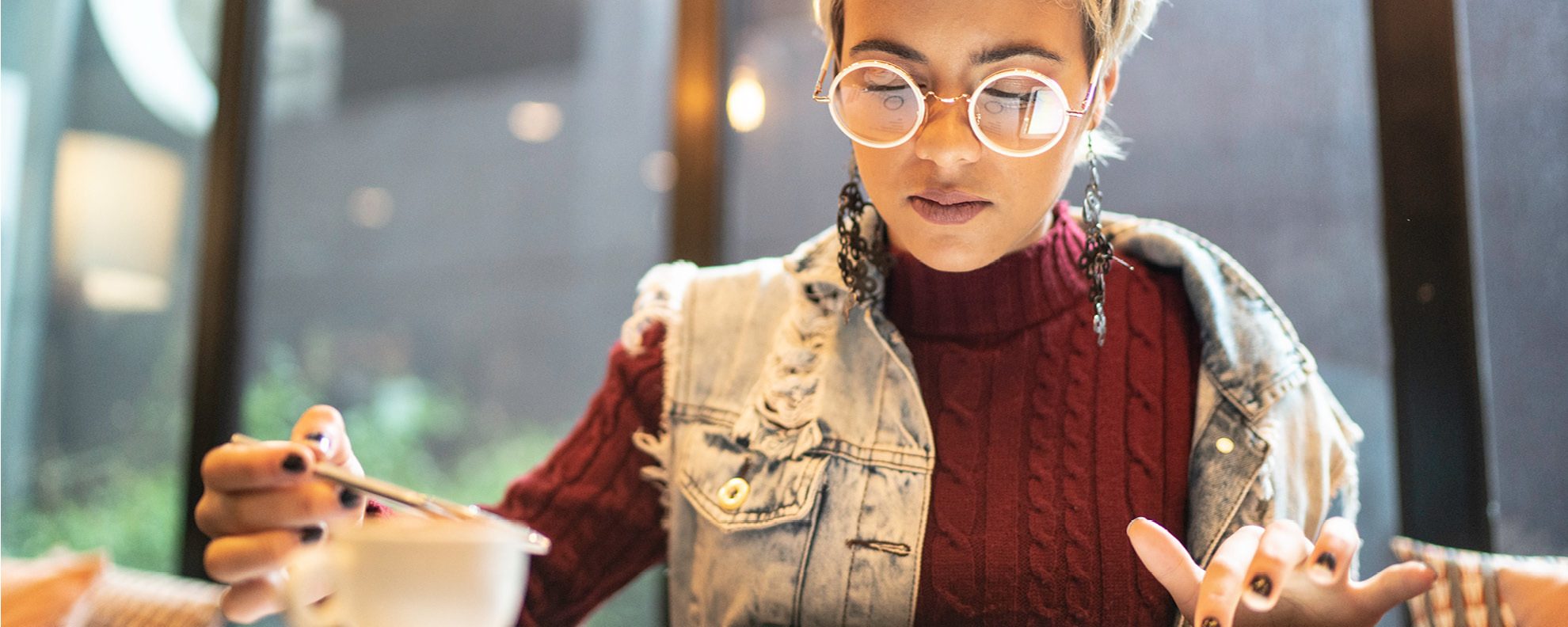 Young woman looking at digital investments on a tablet in cafe